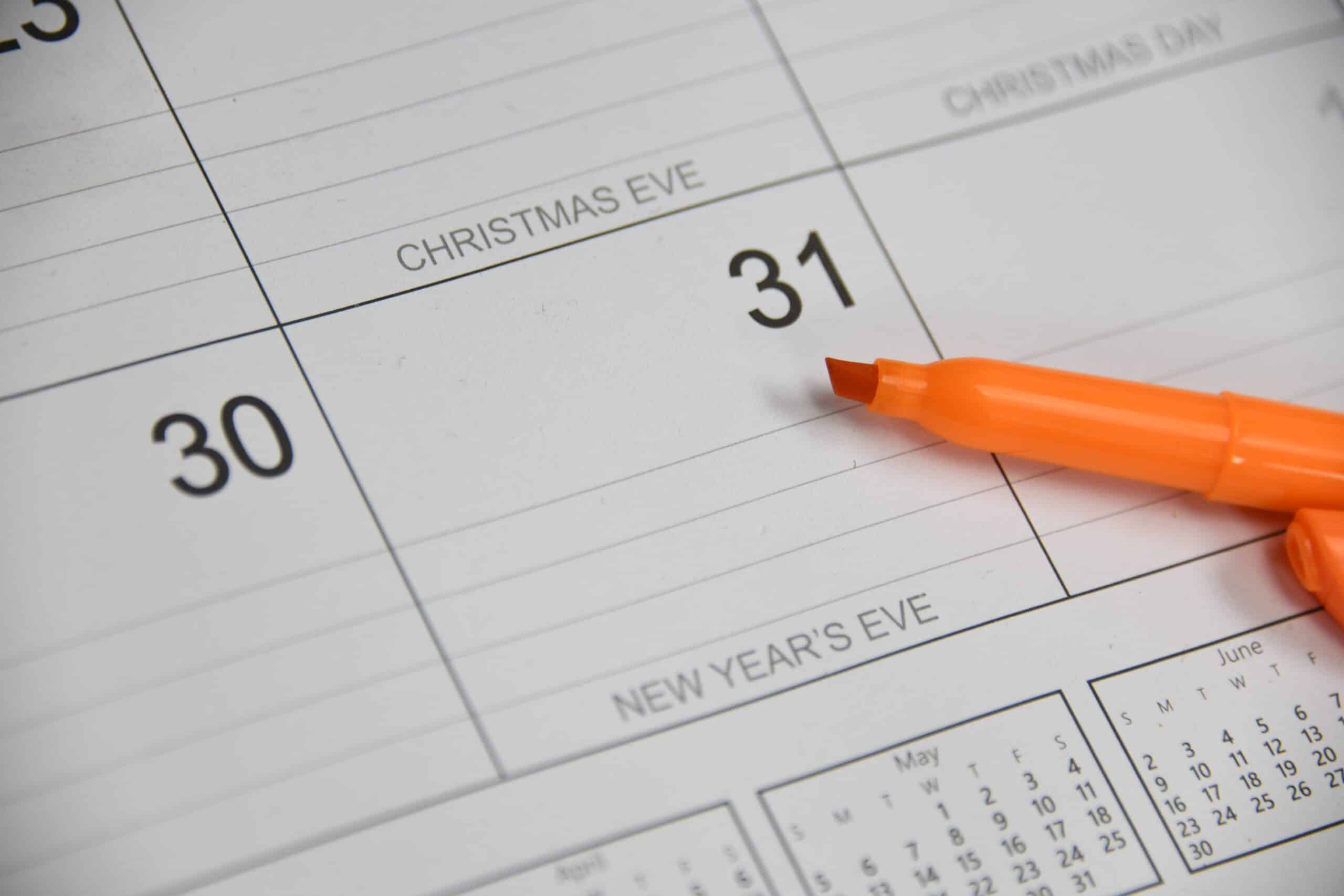 Close-up of a calendar showing the date 31 labeled Christmas Eve, with an orange marker resting along the edge of the box.
